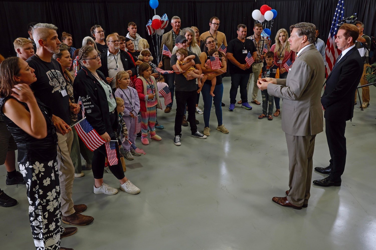 south-africa-refugees-may-12-2025 Newly arrived South Africans listen to U.S. Deputy Secretary of State Christopher Landau and Homeland Security Deputy Secretary Troy Edgar (R) deliver welcome statements in a hangar at Atlantic Aviation Dulles near Washington Dulles International Airport on May 12, 2025 in Dulles, Virginia.