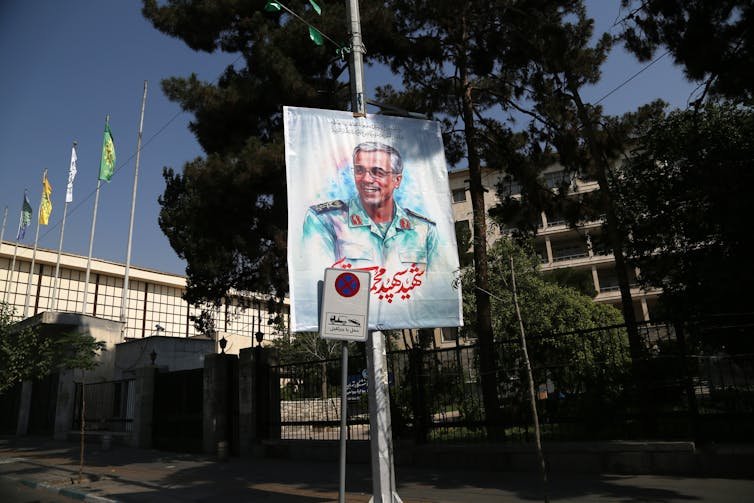 file-20250619-62-u3vgl1 A man's image appears on a street sign poster.