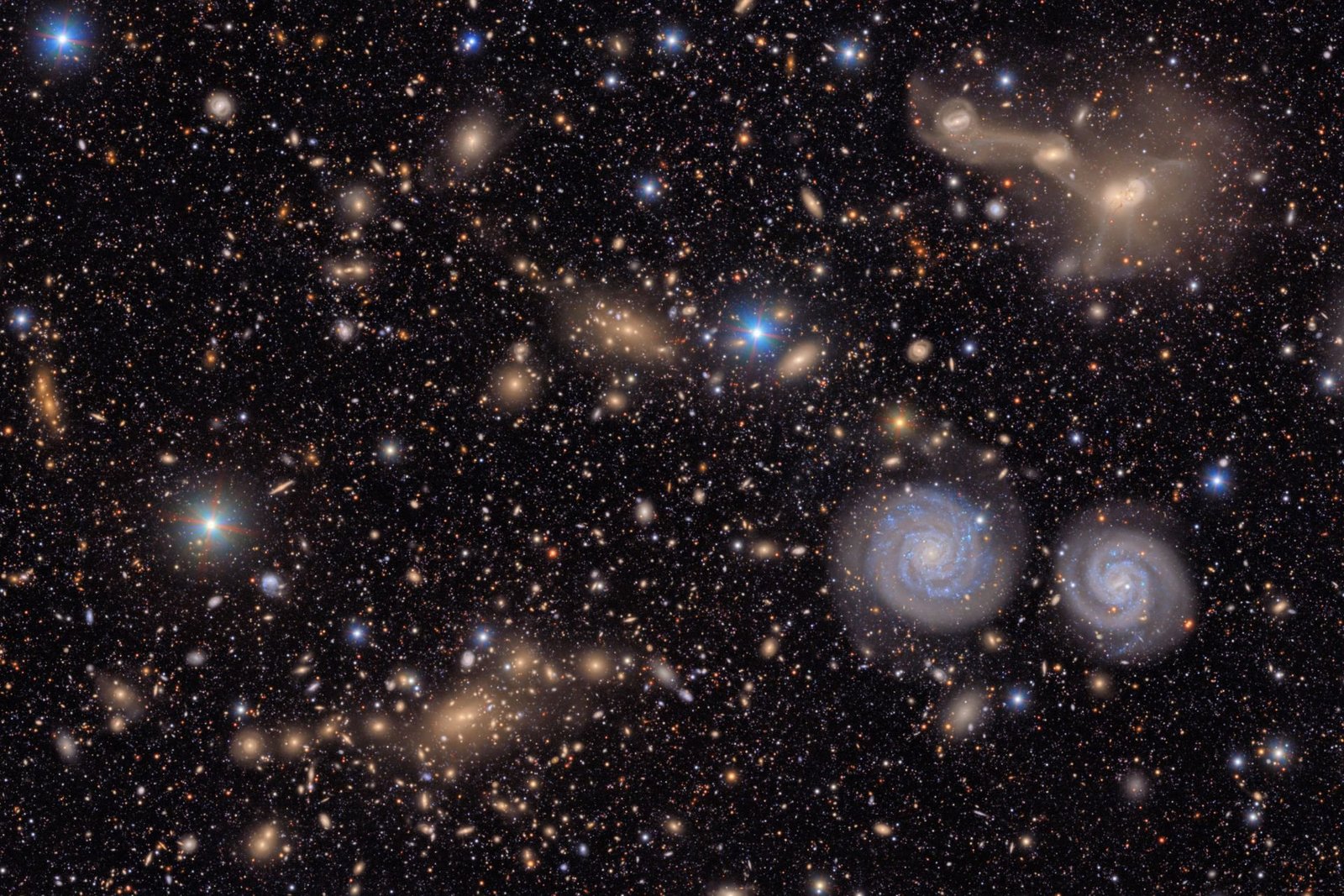 nsf-doe-rubin-virgo-cluster-2-im3crop2 Many stars and galaxies including two spiral galaxies and three merging galaxies.