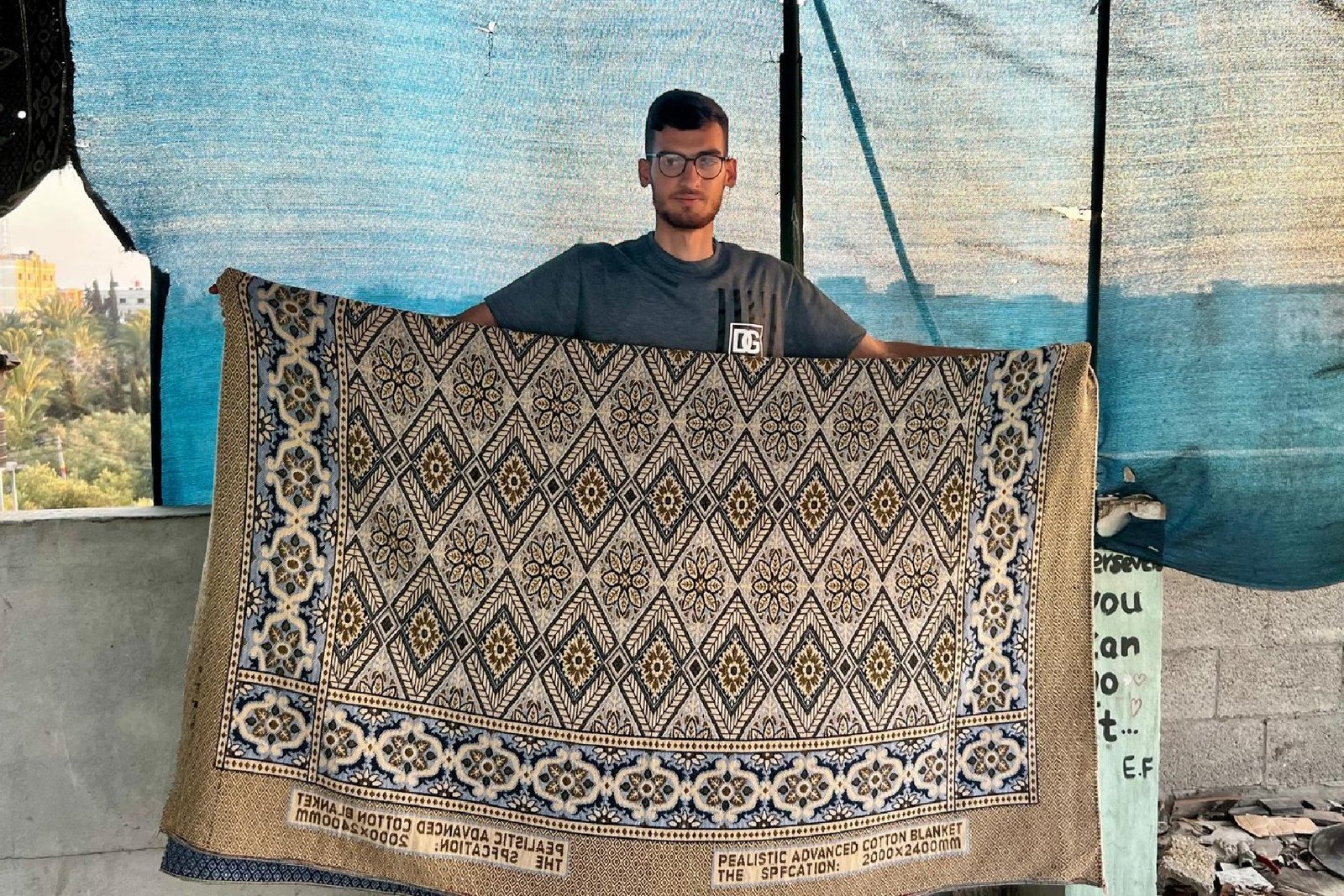 saeed-photo-blanket Saeed Ismail holding the blanket that started a controversy on Bluesky about whether he was AI generated.